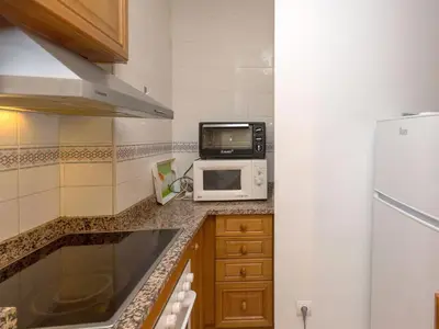a small kitchen with a microwave and a refrigerator at Apartment Primer de Maig by Interhome in Sitges