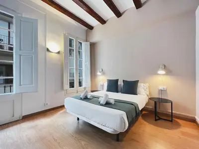 a bedroom with a large white bed and a table at Stay U-nique Apartments Vila de Gracia in Barcelona