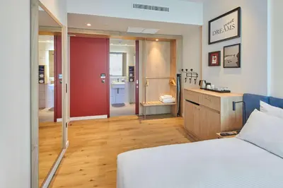 a bedroom with a bed and a red sliding door at Hampton By Hilton Barcelona Fira Gran Via in Hospitalet de Llobregat