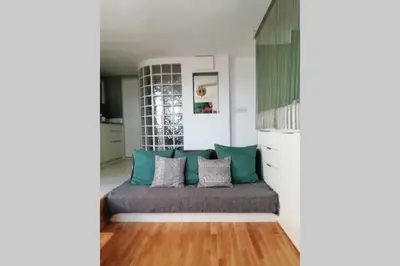 a living room with a couch with blue pillows at Lovely studio, terrace, swim pool, nature, relax!! in Sant Pere de Ribes