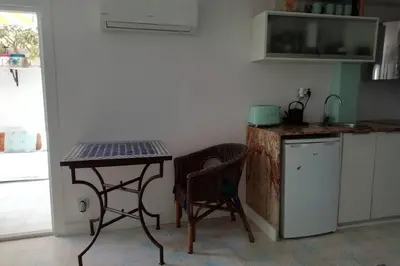 a small kitchen with a table and two chairs at Lovely studio, terrace, swim pool, nature, relax!! in Sant Pere de Ribes