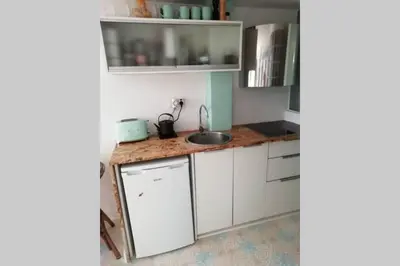 a kitchen with white cabinets and a sink at Lovely studio, terrace, swim pool, nature, relax!! in Sant Pere de Ribes
