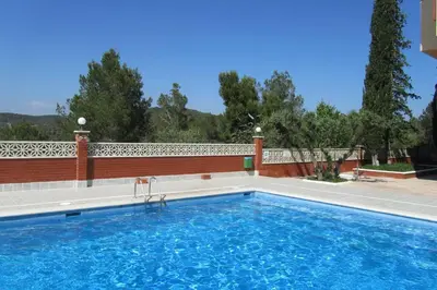 a swimming pool in front of a house at Lovely studio, terrace, swim pool, nature, relax!! in Sant Pere de Ribes