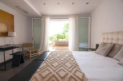 a bedroom with a bed and a desk and a window at Villa Miramar by Glasir in Sitges