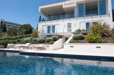 a house with a swimming pool next to a building at Villa Miramar by Glasir in Sitges