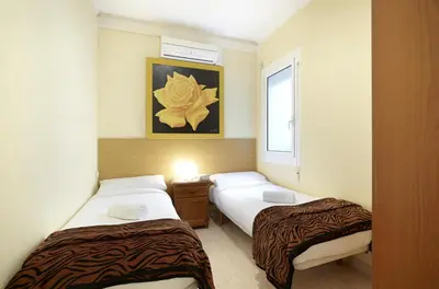 a room with two beds and a window at Apartamentos Calvet in Barcelona
