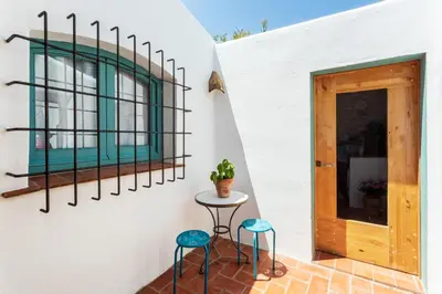 a room with two stools and a table next to a door at Apartamento rústico reformado con encanto (Garraf) in Sant Pere de Ribes
