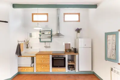 a kitchen with a counter and a refrigerator at Apartamento rústico reformado con encanto (Garraf) in Sant Pere de Ribes