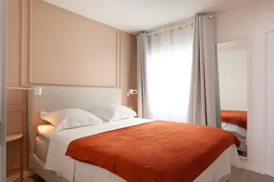 a bedroom with a large bed with an orange blanket at Rambla Catalunya 8 in Barcelona