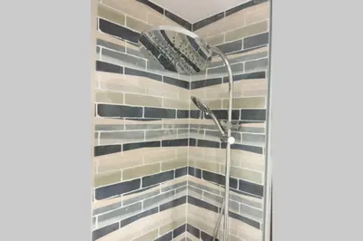 a shower in a bathroom with black and white tiles at M2 Cool apartment next to metro. 15m to center in Esplugues de Llobregat
