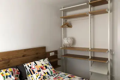 a bedroom with a bed and some wooden shelves at M3 Terrace. Cool apartment 15 min center by metro in Esplugues de Llobregat
