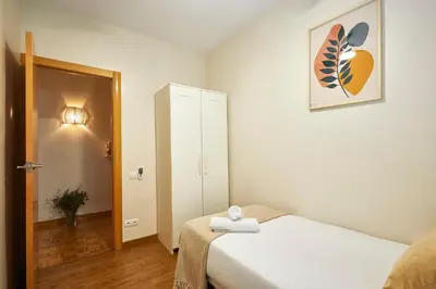 a small room with a bed and a mirror at BBarcelona Marina Flat in Barcelona