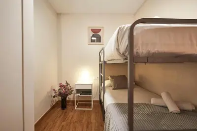a small bedroom with two bunk beds and a desk at BBarcelona Marina Flat in Barcelona