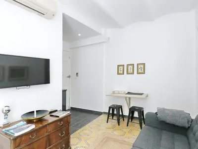 a living room with a couch and a tv and a table at Casa nanit apt a in Hospitalet de Llobregat