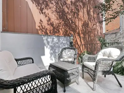 three wicker chairs and a table on a patio at Casa nanit apt c in Hospitalet de Llobregat