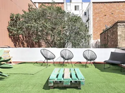 a patio with chairs and a bench and a table at Casa nanit apt c in Hospitalet de Llobregat
