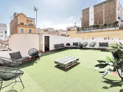 a rooftop patio with chairs and a table on a building at Casa nanit apt d in Hospitalet de Llobregat