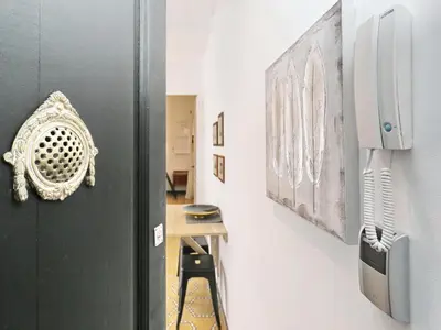 a hallway with a black door and paintings on a wall at Casa nanit apt d in Hospitalet de Llobregat