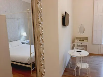 a mirror in a room with a bed and a table at Lumine Luxury Suites by gaiarooms in Barcelona