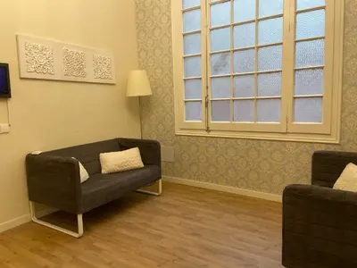 a living room with a couch and a chair at Lumine Luxury Suites by gaiarooms in Barcelona