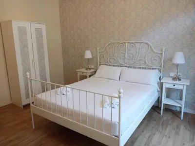 a bedroom with a white bed with two tables and two lamps at Lumine Luxury Suites by gaiarooms in Barcelona