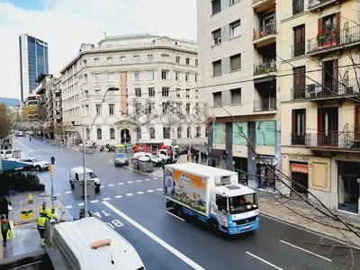 a truck driving down a city street with buildings at Lumine Luxury Suites by gaiarooms in Barcelona