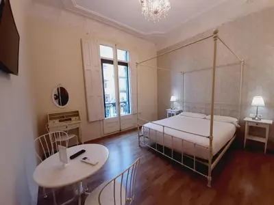 a bedroom with a bed and a desk and a table at Lumine Luxury Suites by gaiarooms in Barcelona
