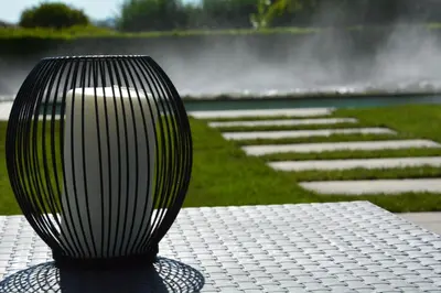 a black vase sitting on a table next to a fountain at Masia Cal Tonarro in San Martín Sarroca