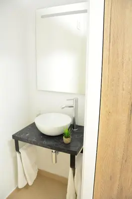 a bathroom with a white sink and a mirror at Masia Cal Tonarro in San Martín Sarroca