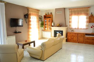 a living room with a couch and a fireplace at Masia Cal Tonarro in San Martín Sarroca
