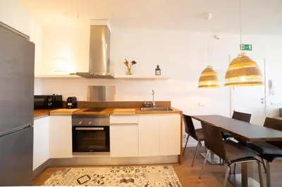a kitchen with a table and a sink and a stove at Apartaments Voralmar in Caldes d'Estrac