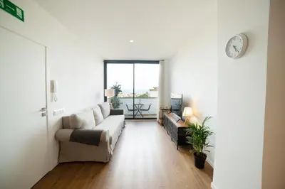 a living room with a couch and a clock on the wall at Apartaments Voralmar in Caldes d'Estrac