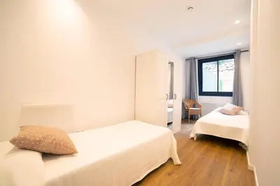 a small bedroom with two beds and a window at Apartaments Voralmar in Caldes d'Estrac