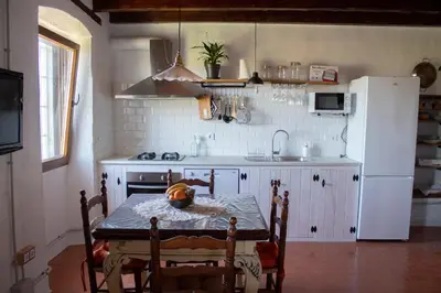 a kitchen with a table and a white refrigerator at Romegosa Benestar in Sant Marçal