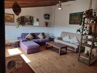 a living room with a purple couch and a table at Romegosa Benestar in Sant Marçal