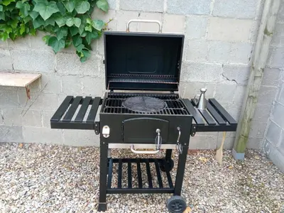 a black barbecue grill sitting in front of a wall at Romegosa Benestar in Sant Marçal