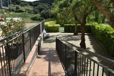 a walkway with a metal fence and a tree at Apartamento Arenys de Munt - Costa Barcelona, Maresme - in Arenys de Munt