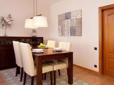 a dining room with a wooden table and white chairs at Click&Flat Luxury mistral in Barcelona