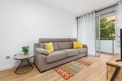 a living room with a couch and a table at Poble Sec 3BR 2BA Balcony Sleeps 7 in Barcelona