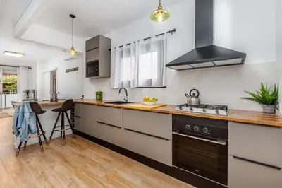 a kitchen with a sink and a stove top oven at Poble Sec 3BR 2BA Balcony Sleeps 7 in Barcelona