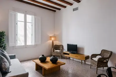 a living room with a couch and a tv at 1840 Apartments Sitges by Suma Hotels in Sitges