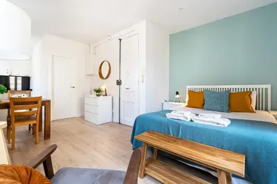 a bedroom with a blue bed and a dining room at Lodging Apartments Barceloneta Beach Studio 31 in Barcelona