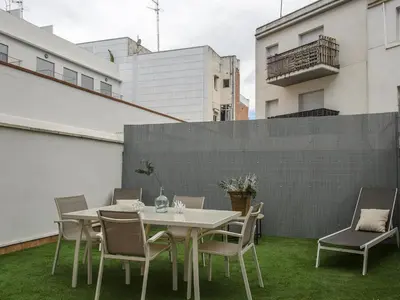 a table and chairs on a patio with grass at Sitges Spaces Terrace Apartment- 1 Bedroom, 1Bathroom, Huge Terrace in Sitges