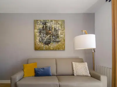 a living room with a couch and a painting on the wall at Sitges Spaces Terrace Apartment- 1 Bedroom, 1Bathroom, Huge Terrace in Sitges