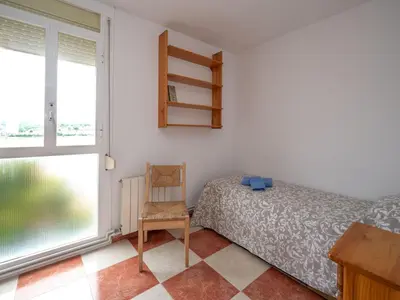 a bedroom with a bed and a chair and a window at Apartment Sun and Beach by Interhome in Cunit