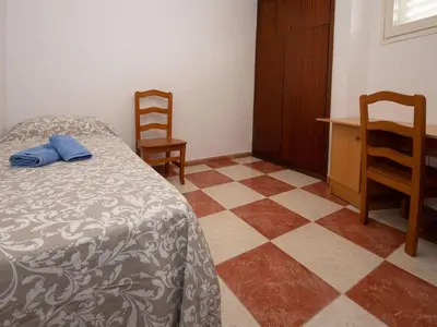 a bedroom with a bed and a desk and chairs at Apartment Sun and Beach by Interhome in Cunit
