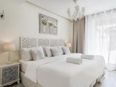 a white bedroom with a large white bed with white pillows at Sitges Spaces Mediterranean Apartments 5 Bedrooms, 4 Bathrooms, 75M2 Terrace, Centre Sitges- Sleeps 11 in Sitges