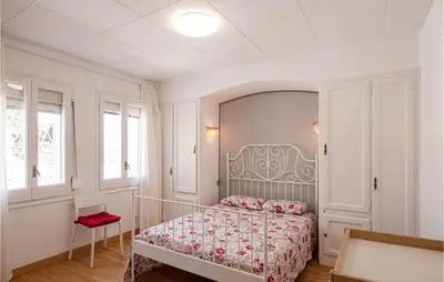 a bedroom with a bed and a red chair at 5 Bedroom Awesome Home In Alella in Alella