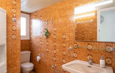 a bathroom with a sink and a toilet and a mirror at 5 Bedroom Awesome Home In Alella in Alella