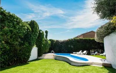 a backyard with a swimming pool and a lawn at 5 Bedroom Awesome Home In Alella in Alella